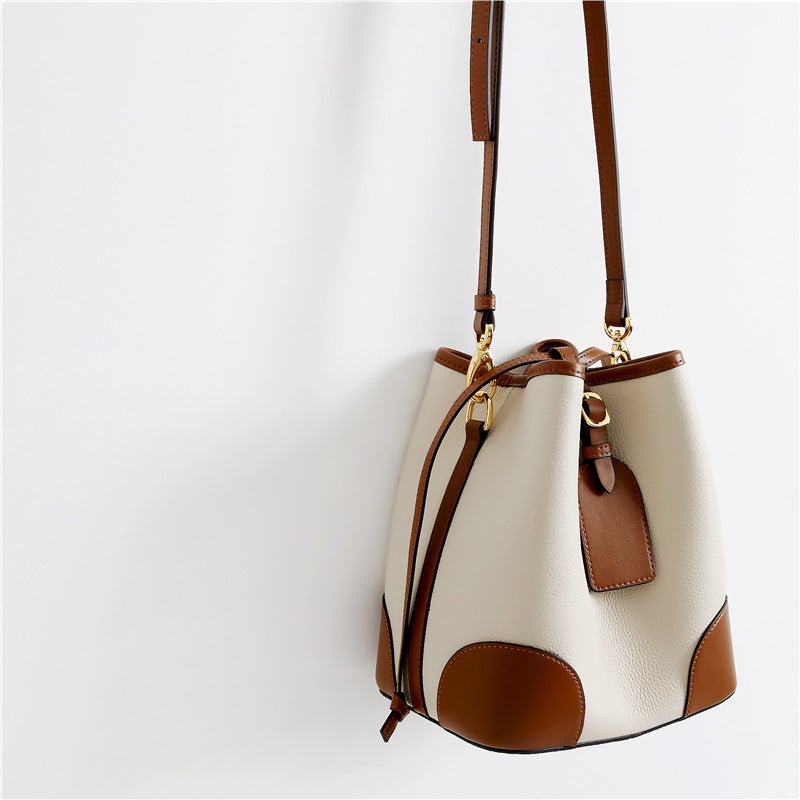 White and brown bucket bag on a light gray background