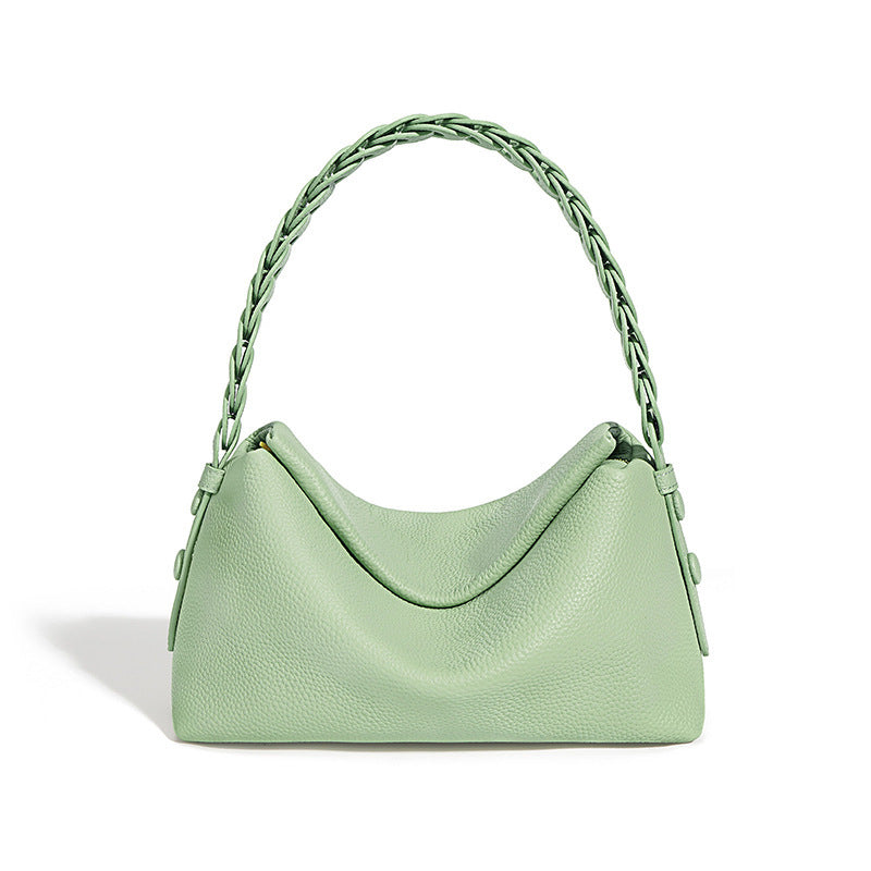 Mint green handbag with braided handle on a white background