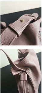 Close-up of a pink leather bag with a buckle on a light background