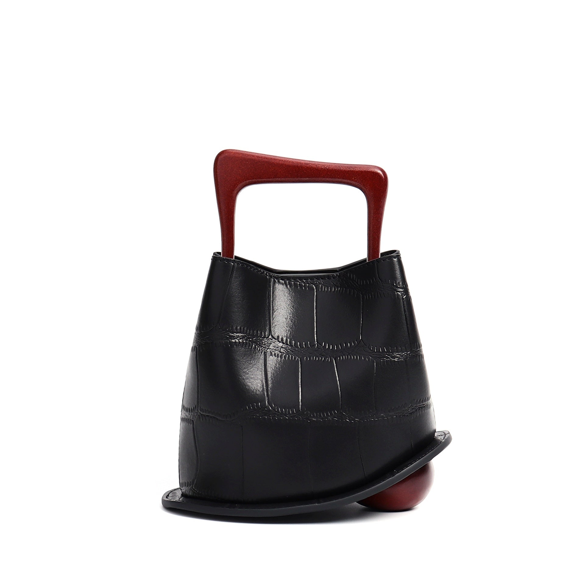 Black leather handbag with a red handle on a white background