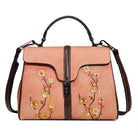 Pink handbag with floral embroidery on a white background