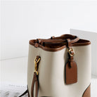Beige handbag with brown accents on a white background