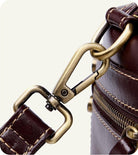 Close-up of a brown leather bag with gold metal clasp on a white background