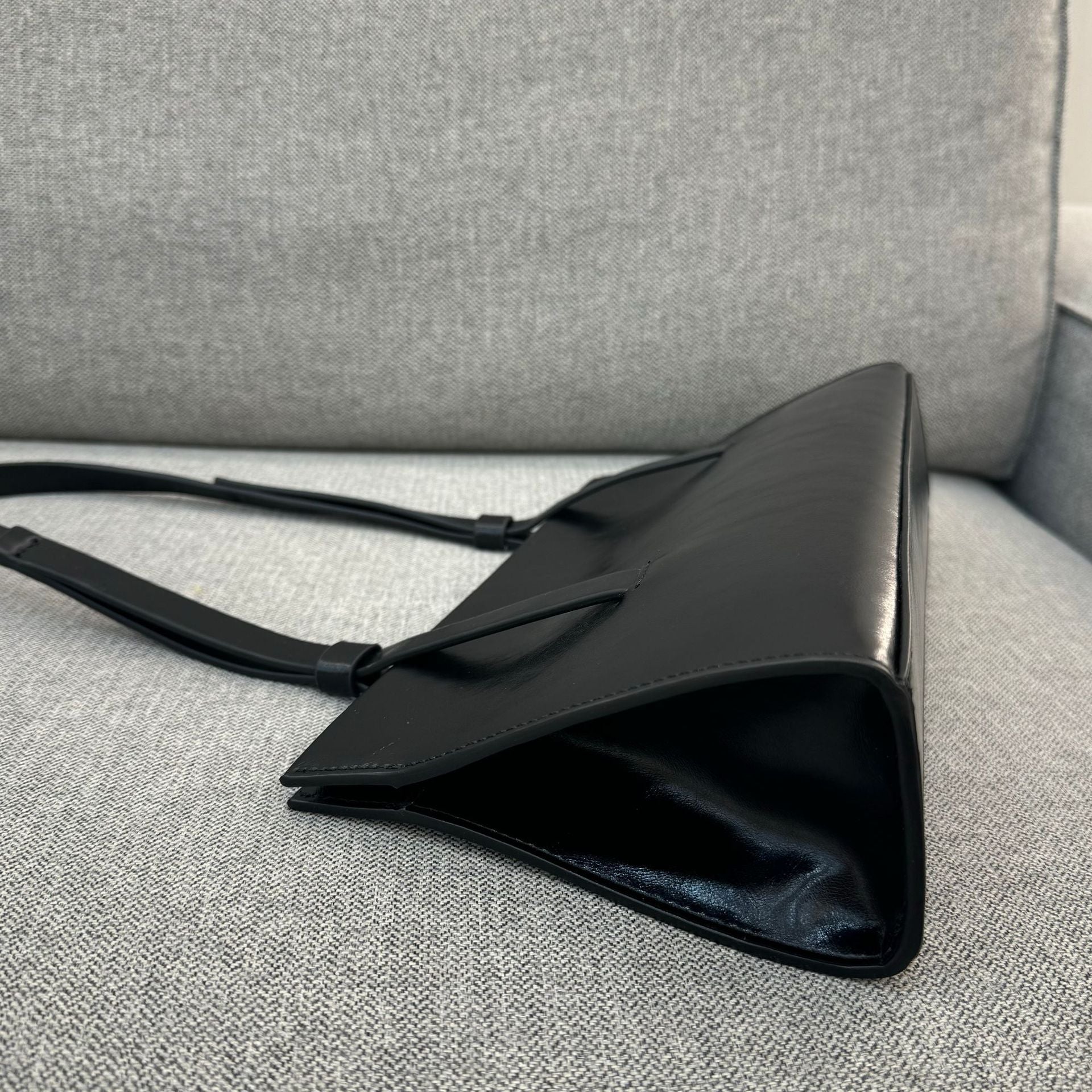 Black handbag on a gray textured surface