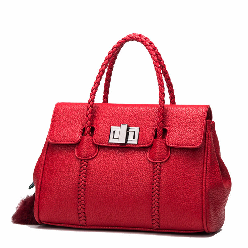 Red handbag with braided handles on a white background