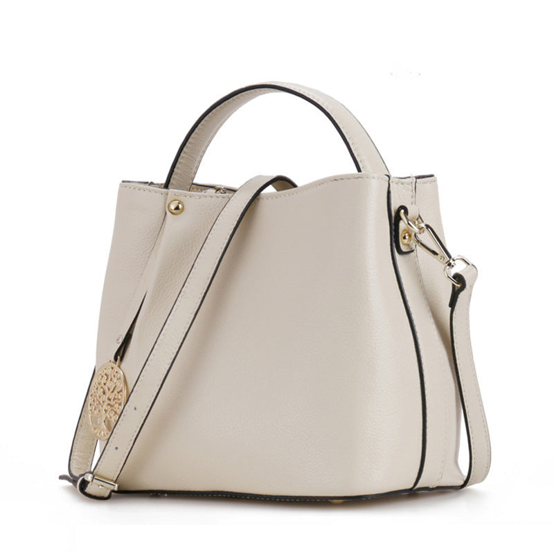 Beige handbag with a shoulder strap on a white background