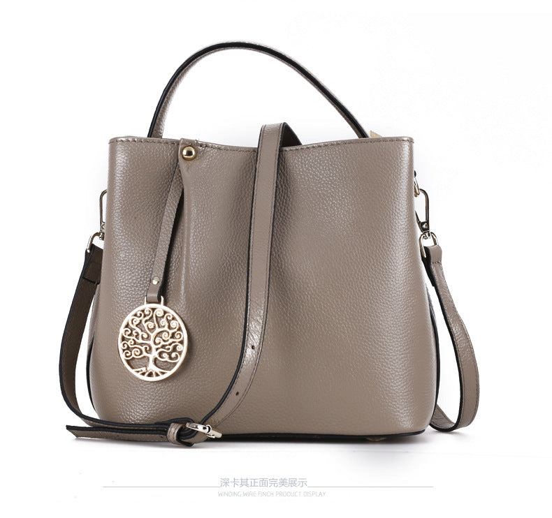 Gray handbag with a decorative pendant on a white background