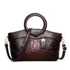 Brown leather handbag with embossed texture on a white background