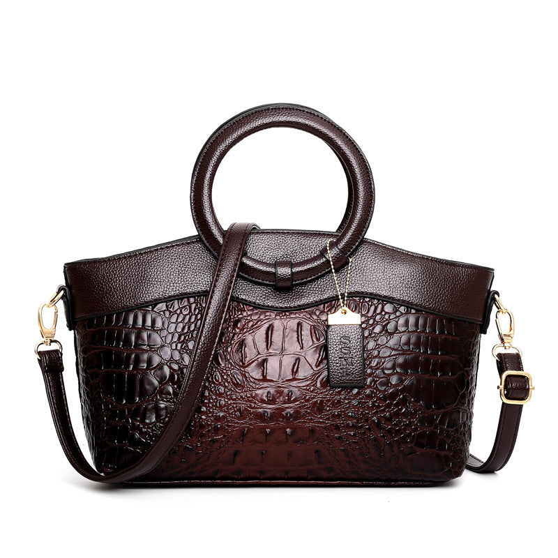 Brown leather handbag with embossed texture on a white background