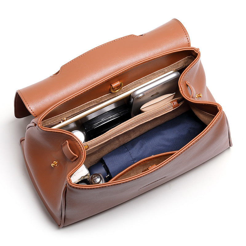 Brown leather toiletry bag with items inside on a white background