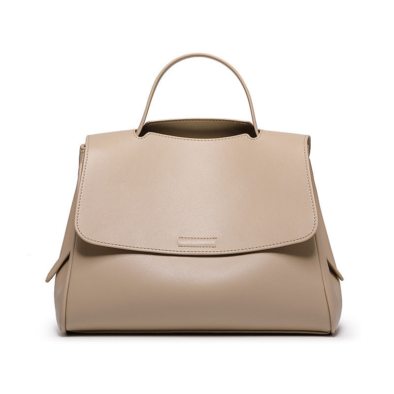 Beige handbag with a flap closure on a white background