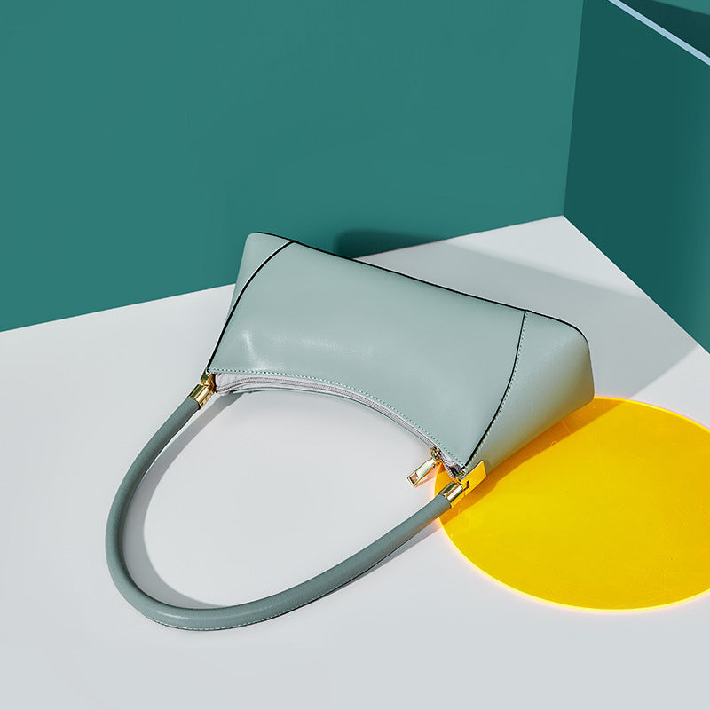 Light blue handbag on a white platform with a yellow circle and teal background