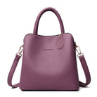 Purple handbag with a shoulder strap on a white background
