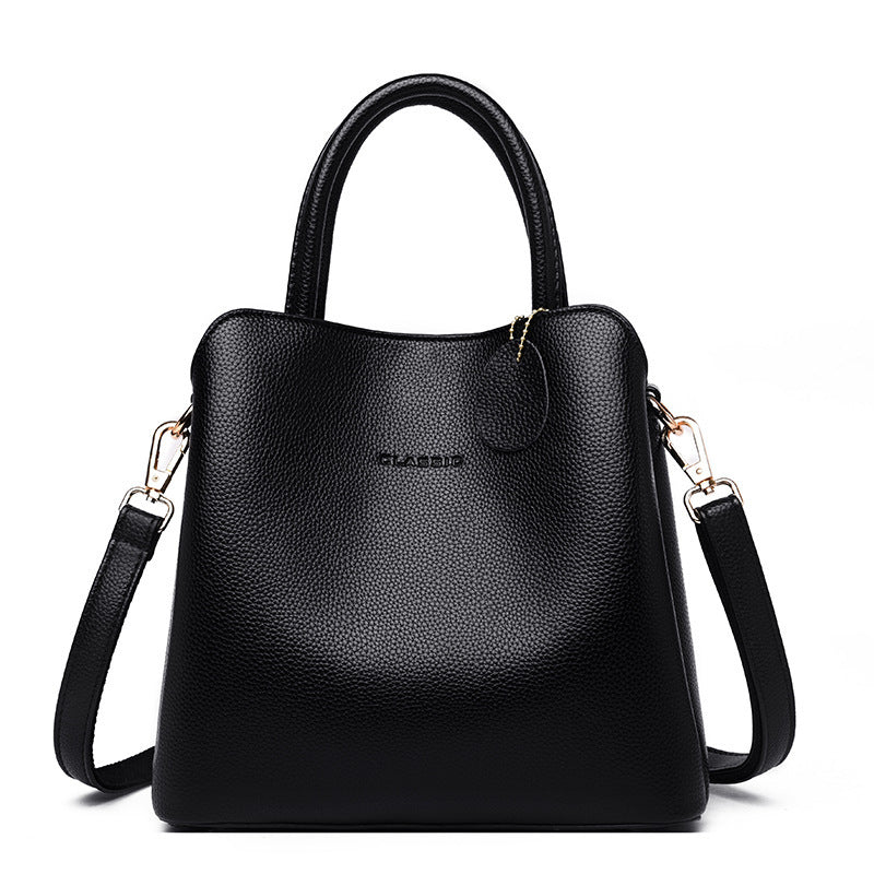 Black handbag with a shoulder strap on a white background