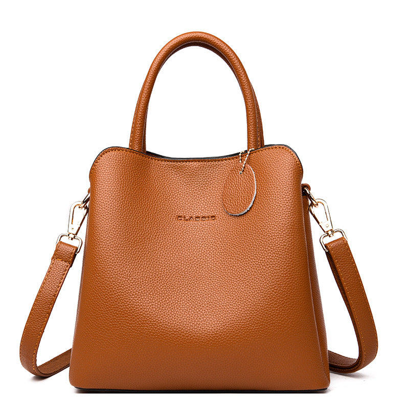 Brown leather handbag with a shoulder strap on a white background