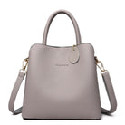Gray handbag with a shoulder strap on a white background