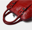 Red textured handbag with a strap on a light gray background
