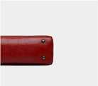 Red leather wallet with silver buttons on a light gray background