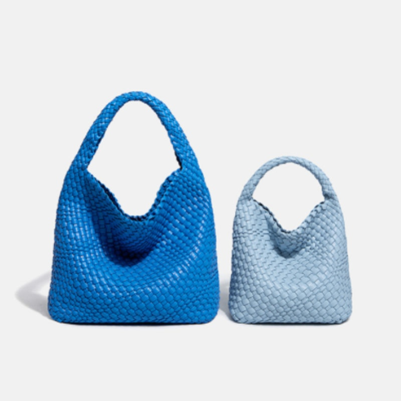 Two blue handbags, one larger and one smaller, on a light gray background.