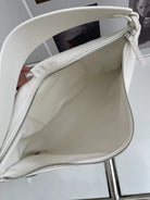 White handbag held open with a blurred background