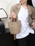 Woman holding a beige handbag indoors