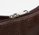 Close-up of a brown leather bag with a silver zipper