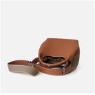 Brown leather handbag with a strap on a white background