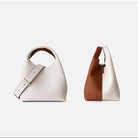 Two handbags, one white and one with a brown section, on a light gray background.