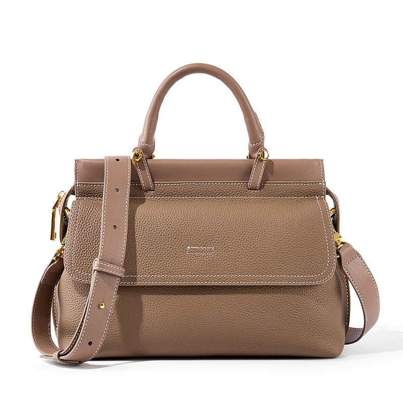 Brown leather handbag with gold accents on a white background