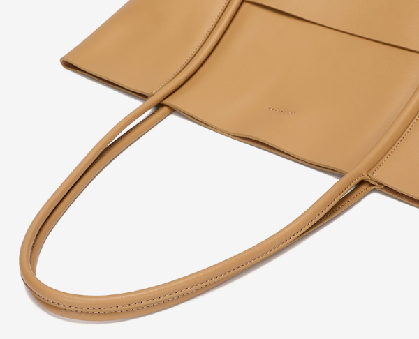 Tan leather handbag with visible brand name on a white background