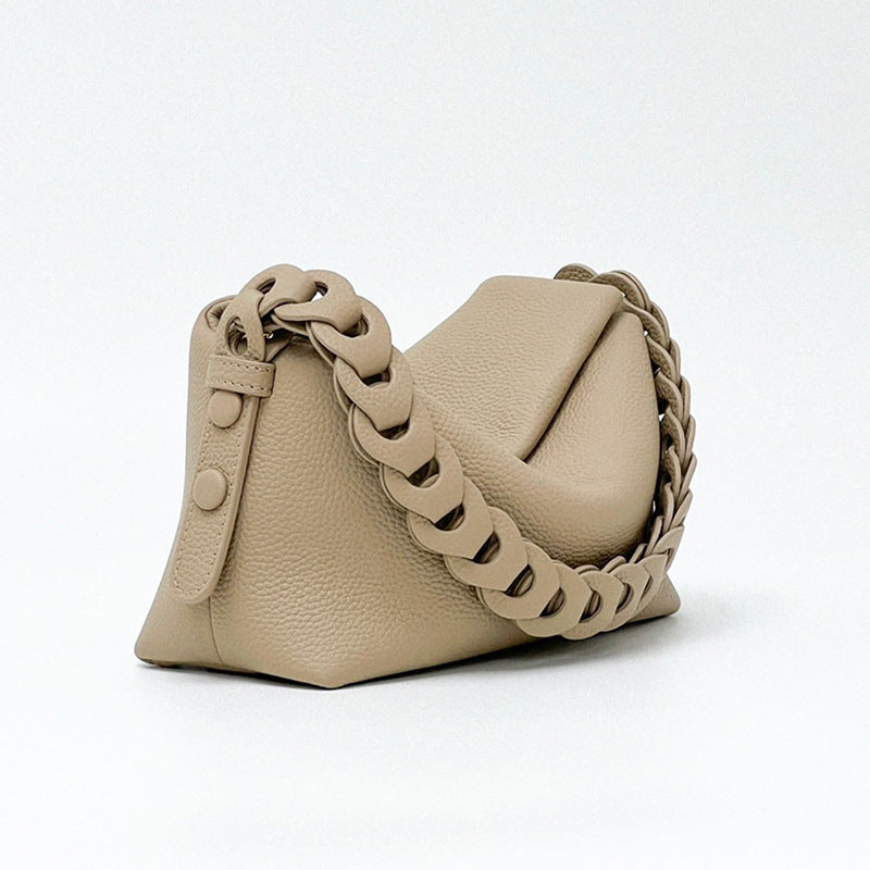 Beige handbag with a braided chain strap on a white background