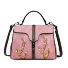 Pink handbag with floral embroidery on a white background