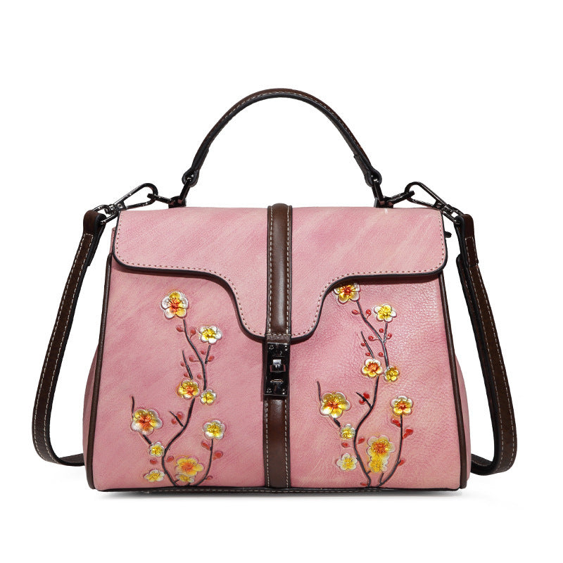 Pink handbag with floral embroidery on a white background