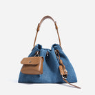 Blue denim handbag with brown leather accents on a white background