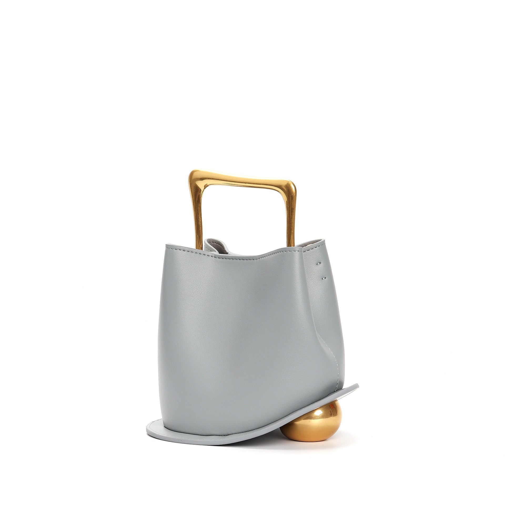 Gray handbag with a gold handle on a white background