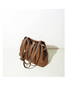 Brown suede handbag on a white background