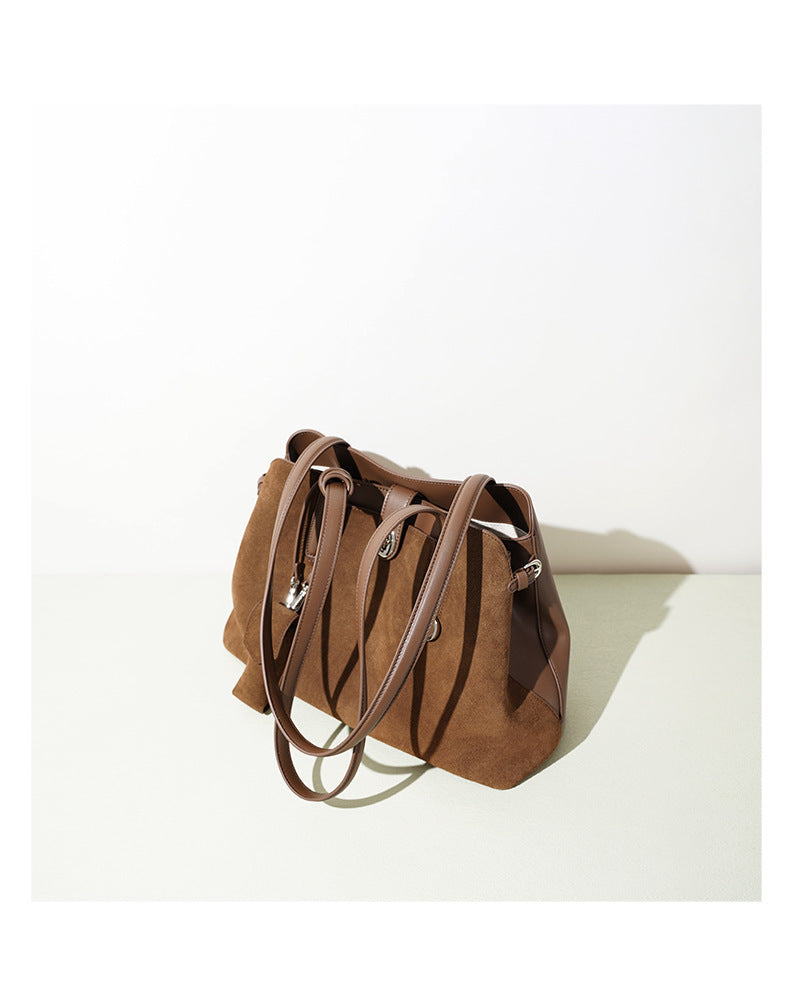 Brown suede handbag on a white background
