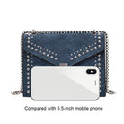 Blue studded handbag next to a 6.5-inch mobile phone on a white background