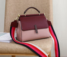 Burgundy handbag with a colorful strap on a chair
