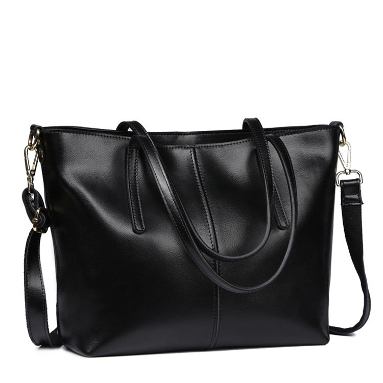 Black leather handbag with a shoulder strap on a white background