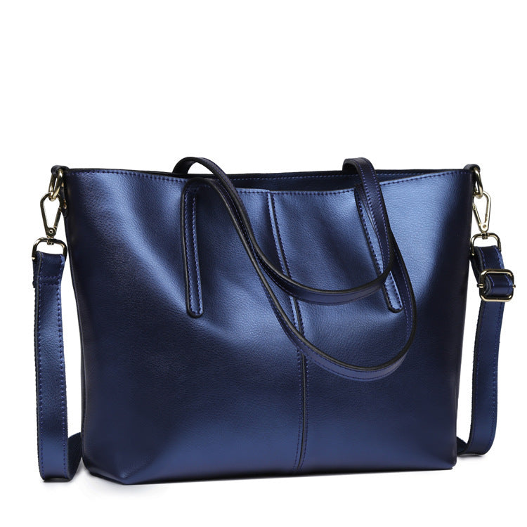 Blue handbag with a shoulder strap on a white background