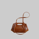 Brown handbag with a strap on a beige background