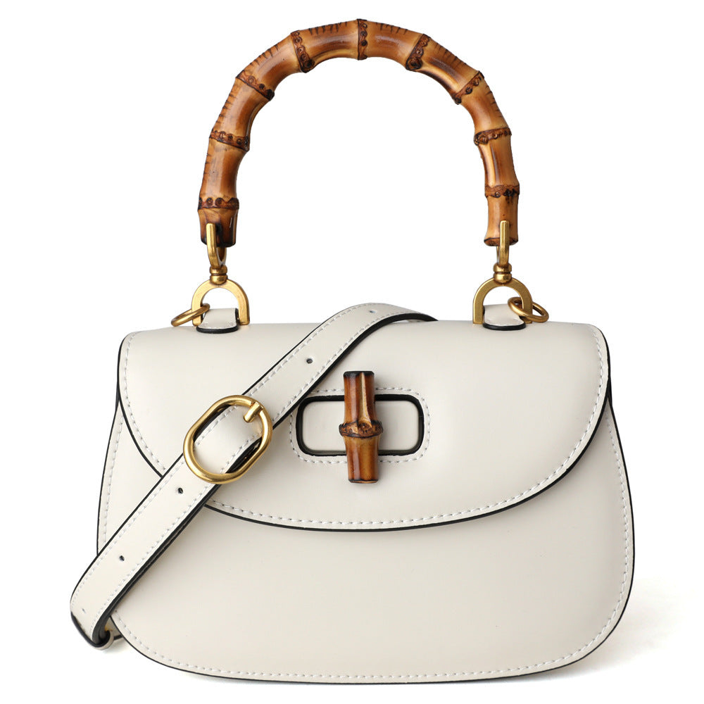White handbag with wooden handle and bamboo accents on a white background
