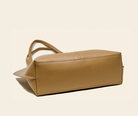 Tan leather handbag on a beige background
