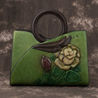 Green handbag with floral design on a textured brown background