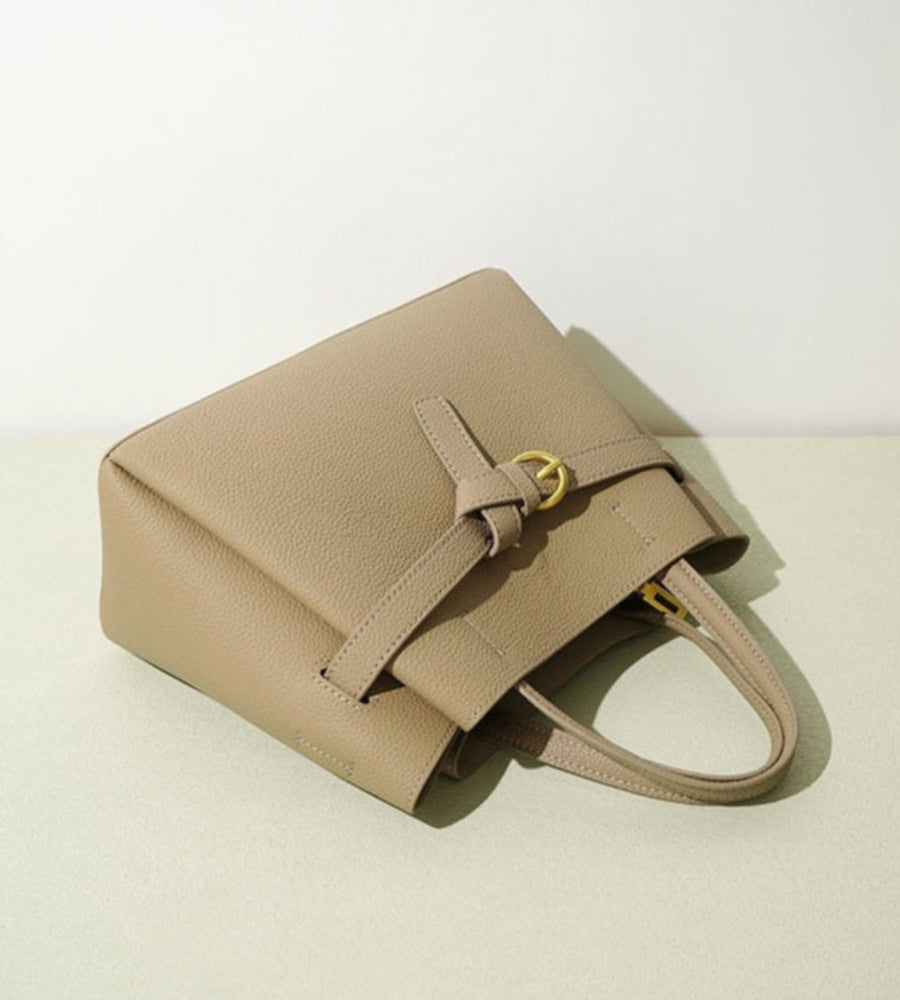 Beige handbag on a light beige background with text about the bag's features.