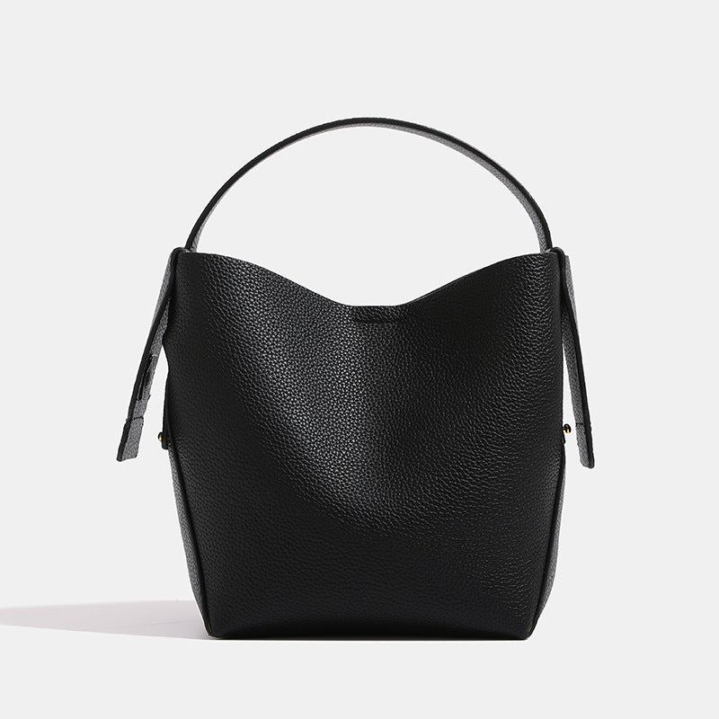 Black leather handbag on a light gray background