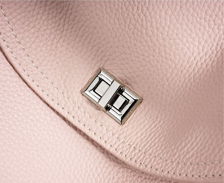 Close-up of a pink leather handbag with a silver clasp.