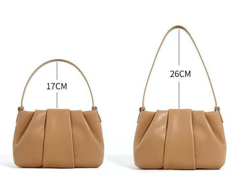 Tan handbag with measurements of underarm/shoulder strap on a white background