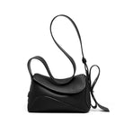 Black leather handbag with a strap on a white background